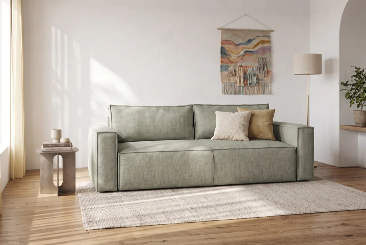 Sofa i støvet grøn farve som fokuspunkt i en lys stue